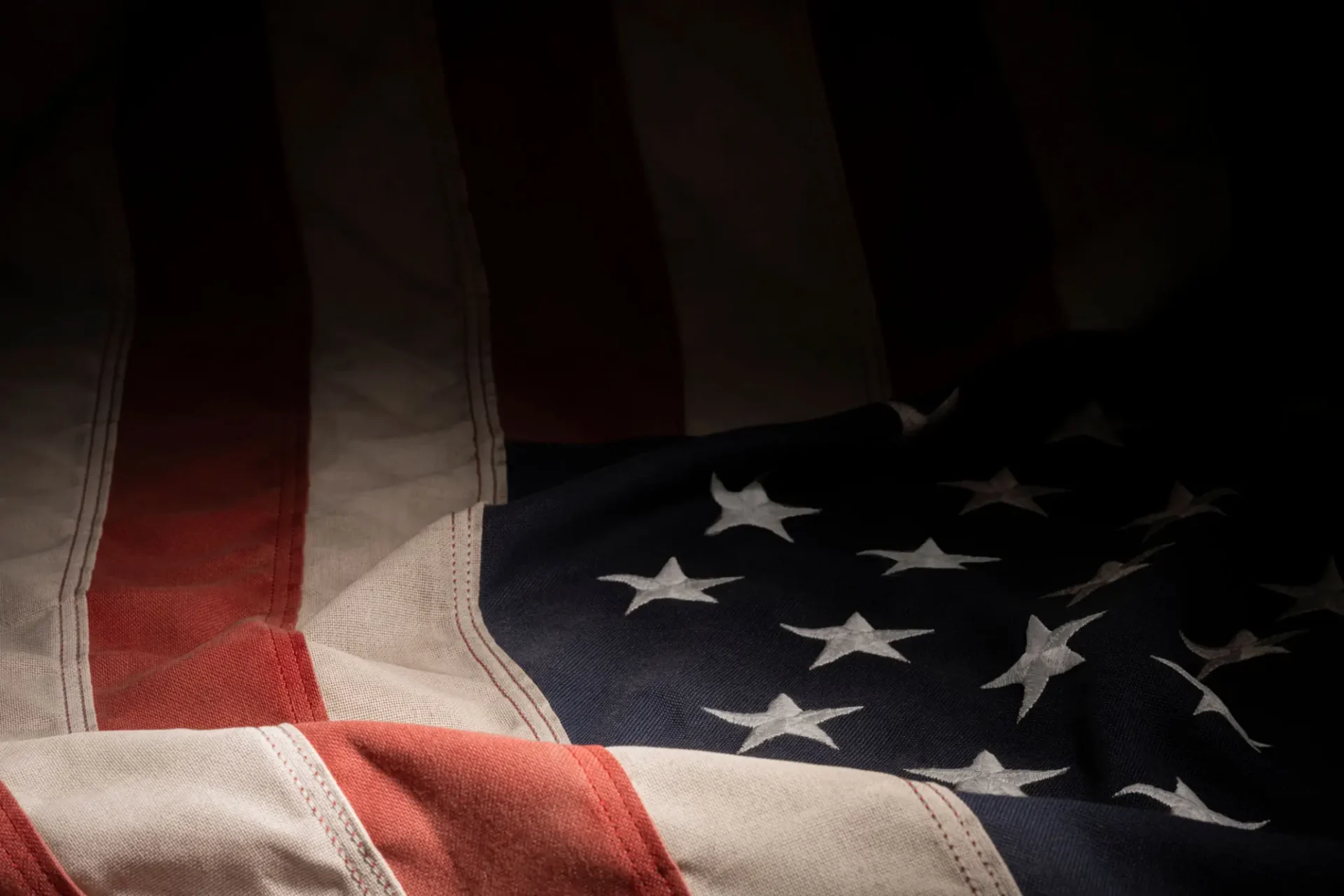 American flag in the dark, with its iconic red, white, and blue colors and stars, symbolizing the of America