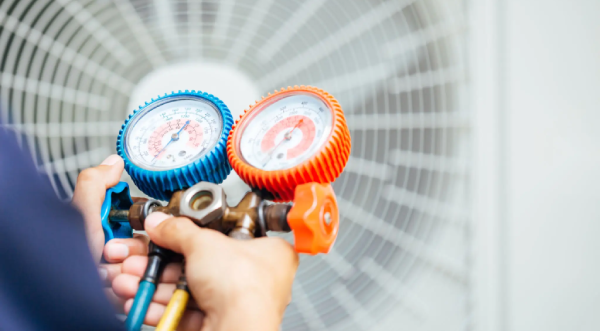 Technician inspecting rooftop air conditioning units.